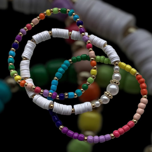 Rainbow Luxe bracelet stack – white clay, rainbow seed beads, and gold accents

Handmade colourful bracelet set with pearl-look beads – Rainbow Luxe

Bright 3-piece bracelet stack with rainbow tones and gold details

White and gold beaded stretch bracelets with rainbow highlights

Joyful handmade bracelet trio with pearls and polymer discs – UK made