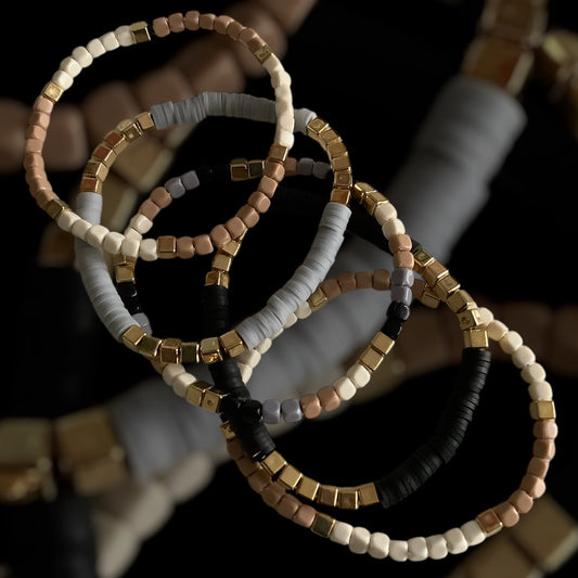 Stone Blend bracelet stack – neutral beads and gold cube spacers

Handmade stretch bracelet trio in grey, taupe, ivory, and blush

Neutral beaded bracelet set with gold accents – Stone Blend by Pxl Nate

Textured 3-piece bracelet stack with matte cube beads and clay discs

Earthy toned bracelet trio with polymer and glass beads – UK handmade